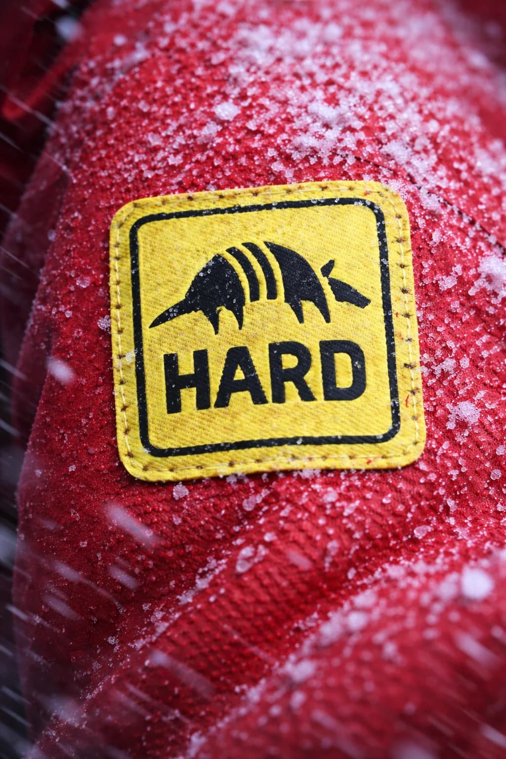 Parche amarillo de Hardcondition sobre indumentaria roja cubierta de nieve